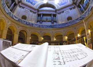 Architectural drawing are displayed on a bench in the rotunda.